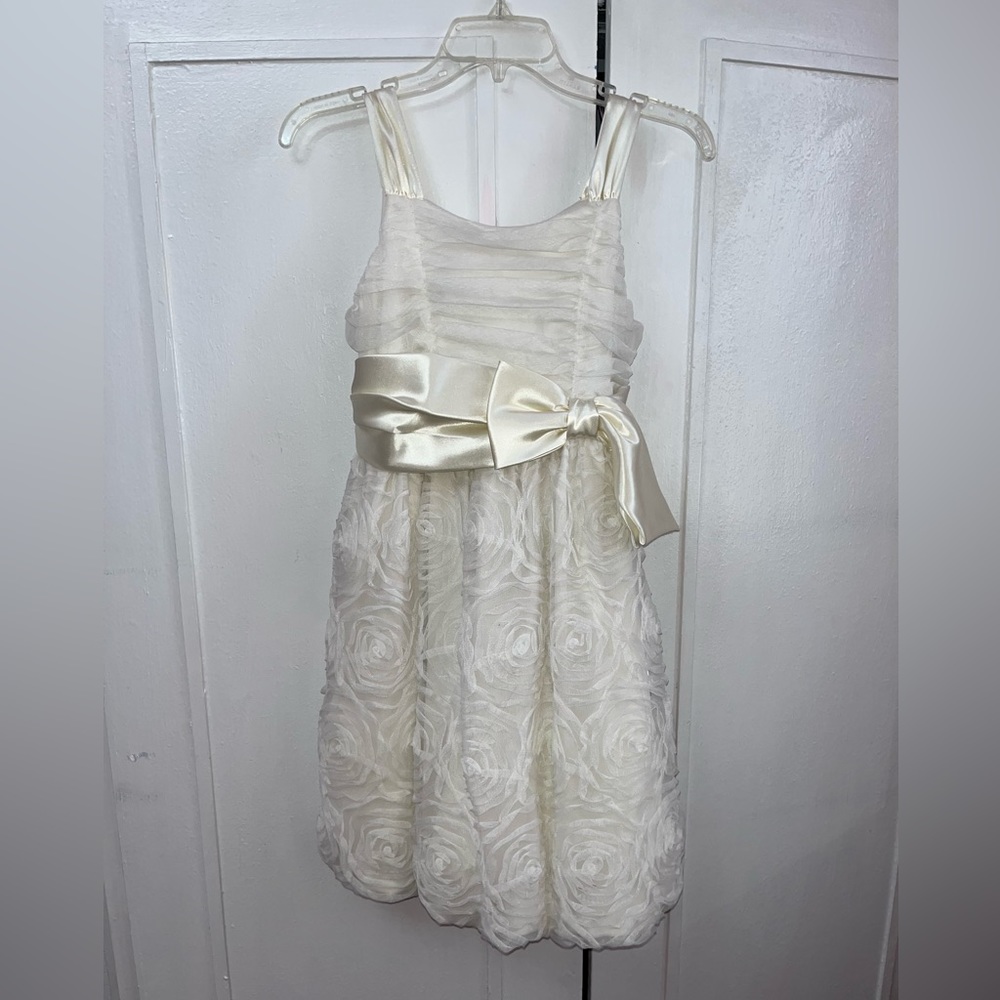 This beautiful Bonnie Jean dress in a classy cream color is size 14 kids.